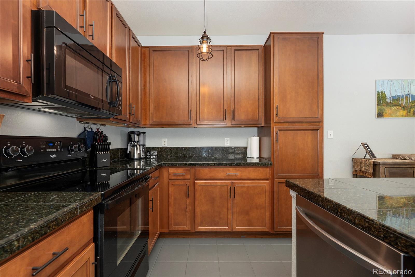 154 Village Road, Unit C103 Granby, CO 80446 - Photo 25 of 39 a kitchen with stainless steel appliances granite countertop a stove a sink and a microwave