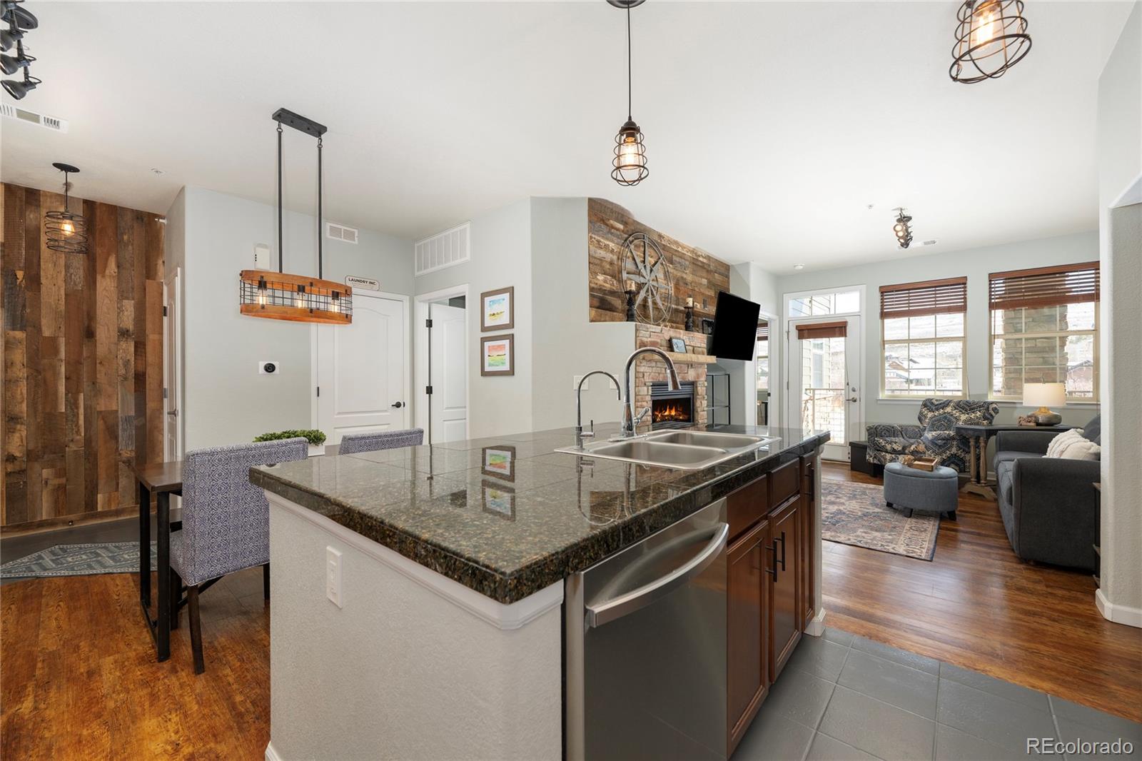 154 Village Road, Unit C103 Granby, CO 80446 - Photo 28 of 39 a kitchen with stainless steel appliances granite countertop a sink a stove and a wooden floor