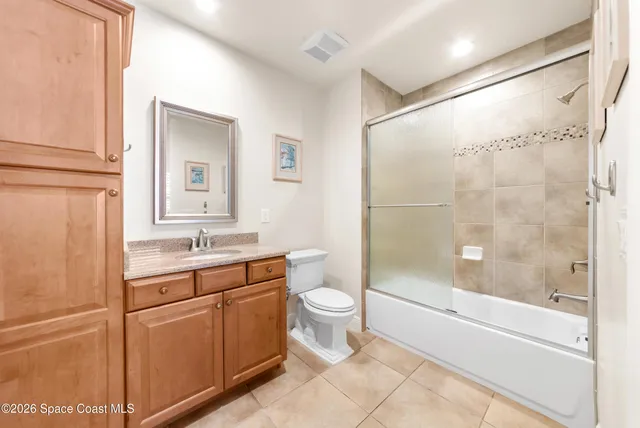a view of a kitchen with refrigerator and white cabinets