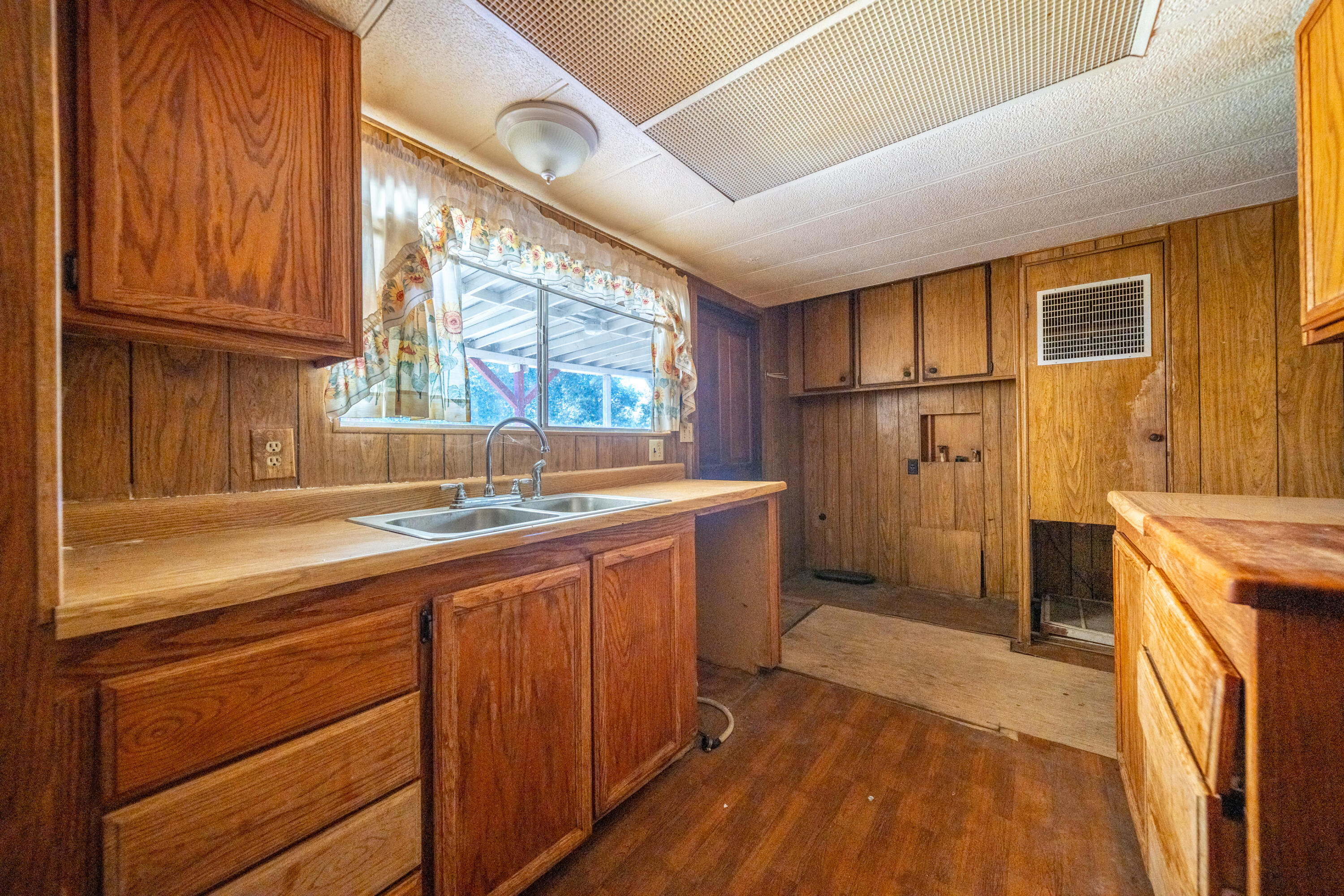 18355 Benson Road Cottonwood, CA 96022 - Photo 8 of 18 a kitchen with a sink and wooden cabinets