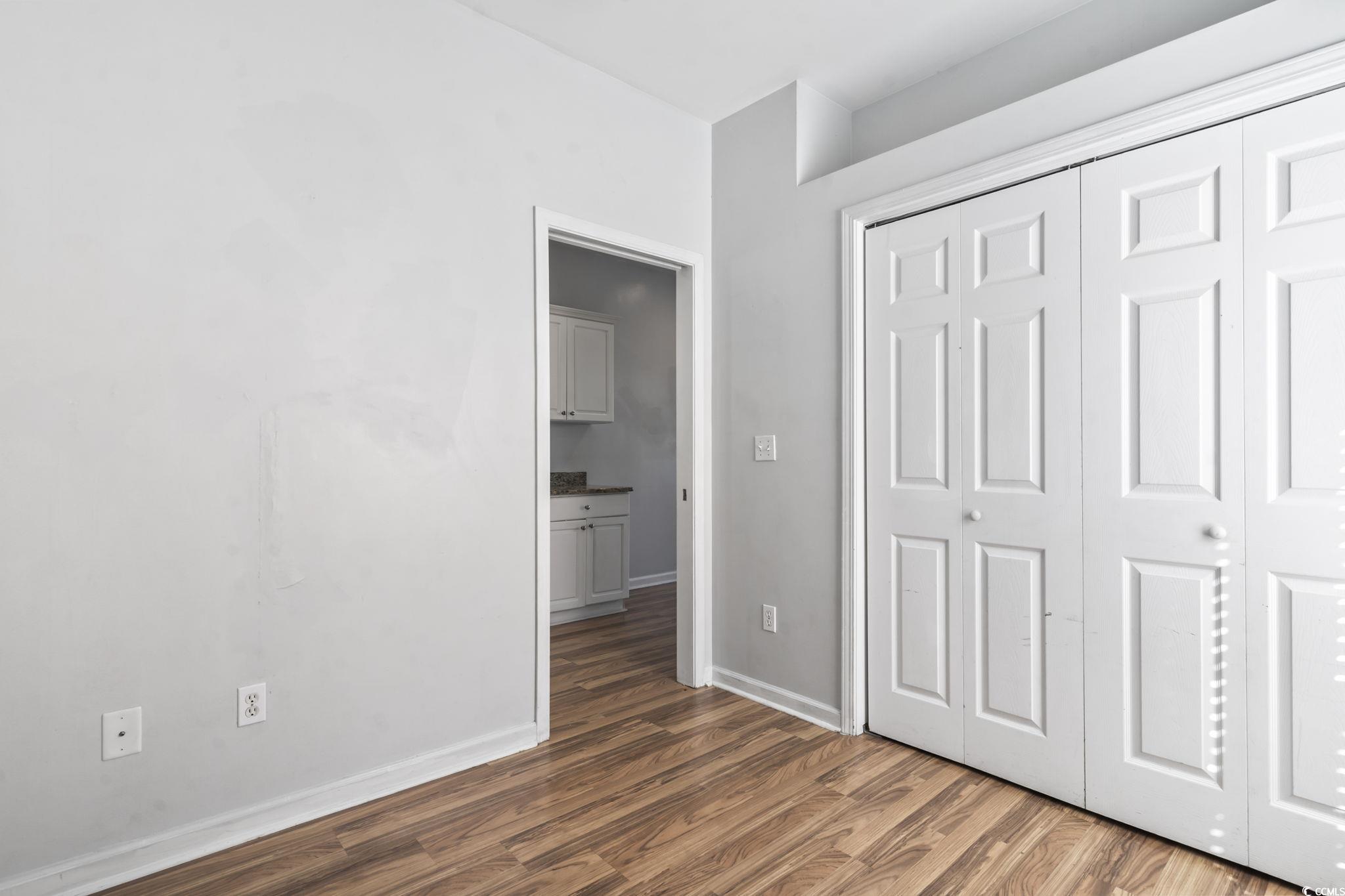 191 Addison Cottage Way Murrells Inlet, SC 29576 - Photo 12 of 28 Unfurnished bedroom featuring dark wood-style flooring and a closet