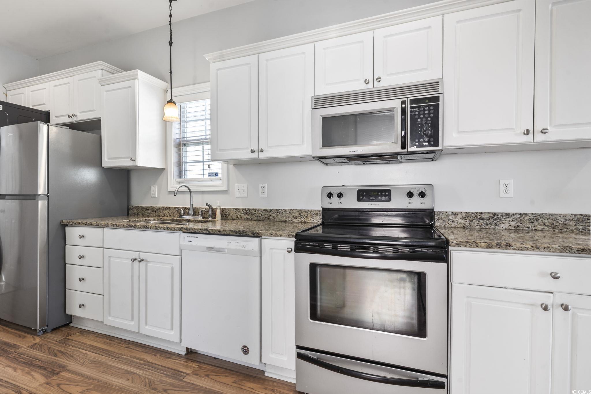 191 Addison Cottage Way Murrells Inlet, SC 29576 - Photo 13 of 28 Kitchen with appliances with stainless steel finishes, white cabinetry, decorative light fixtures, and dark stone countertops