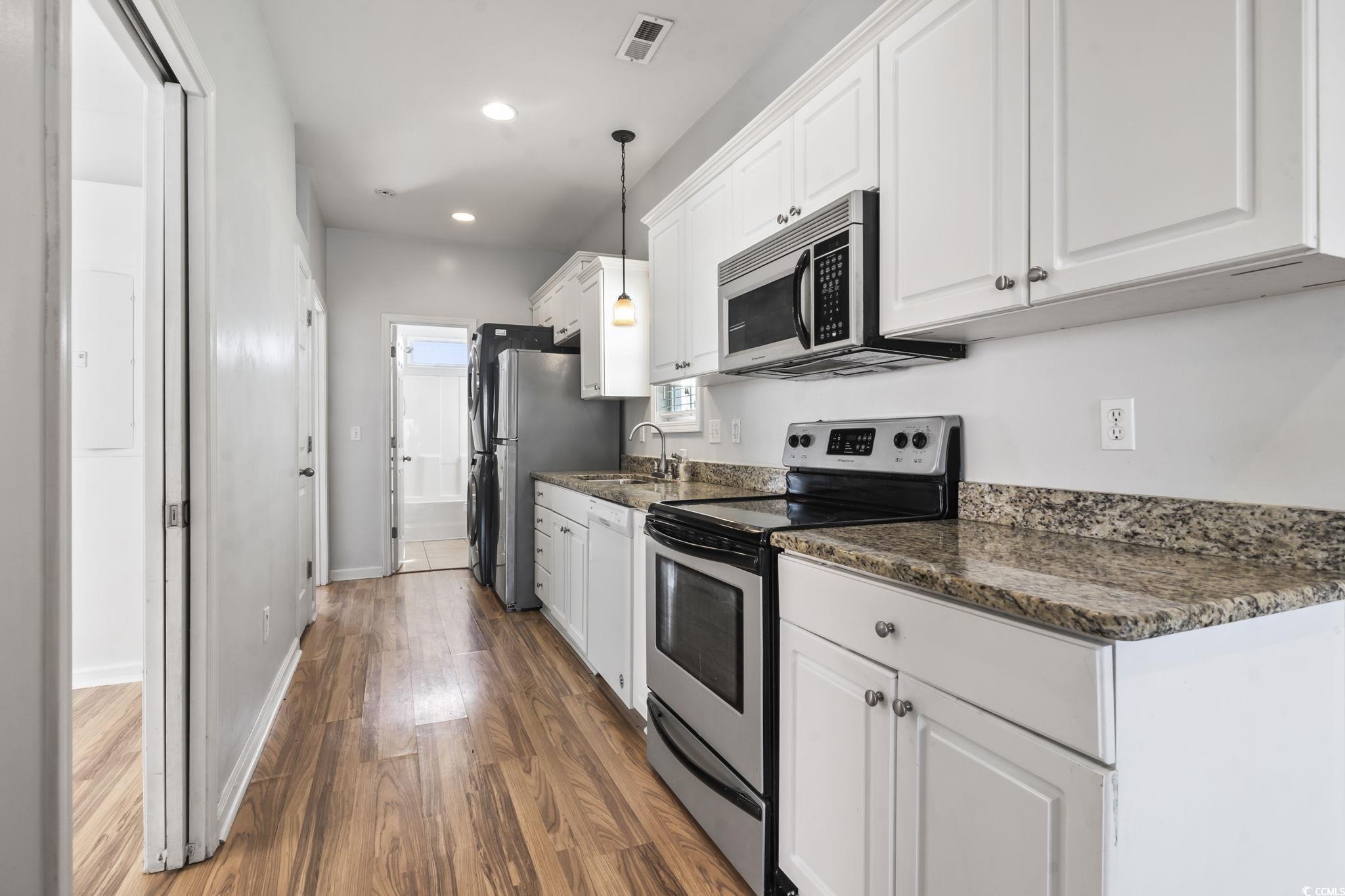 191 Addison Cottage Way Murrells Inlet, SC 29576 - Photo 9 of 28 Kitchen with appliances with stainless steel finishes, white cabinets, dark wood finished floors, hanging light fixtures, and recessed lighting