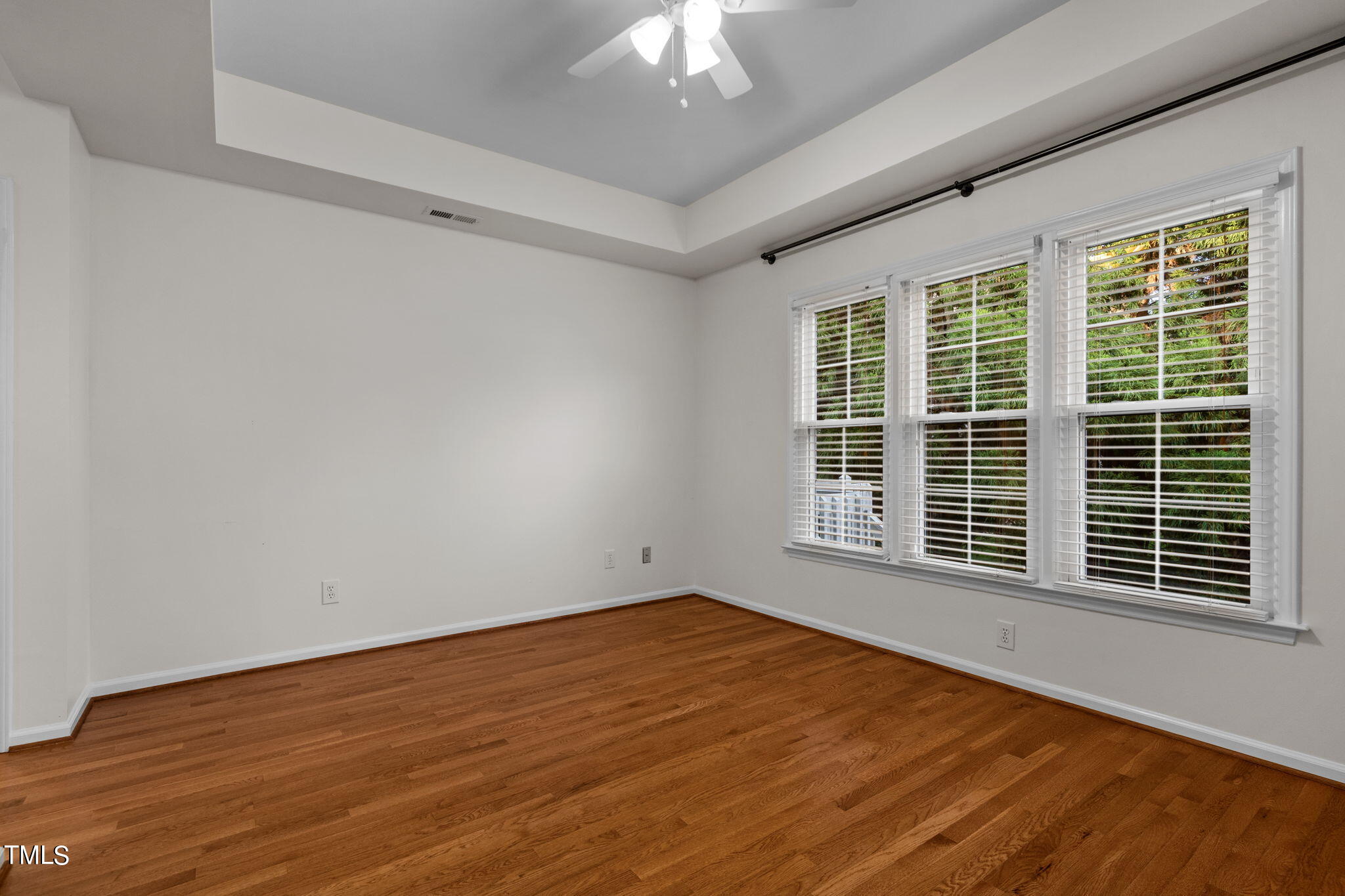 8241 Hempshire Place, Unit 102 Raleigh, NC 27613 - Photo 14 of 30 a view of an empty room with wooden floor and a window