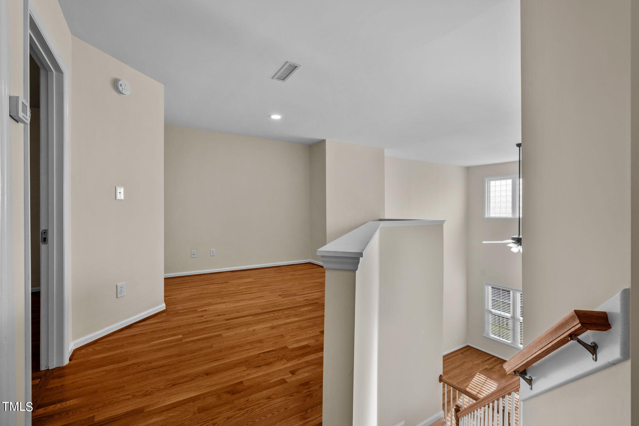 8241 Hempshire Place, Unit 102 Raleigh, NC 27613 - Photo 15 of 30 a view of an empty room with wooden floor and a window