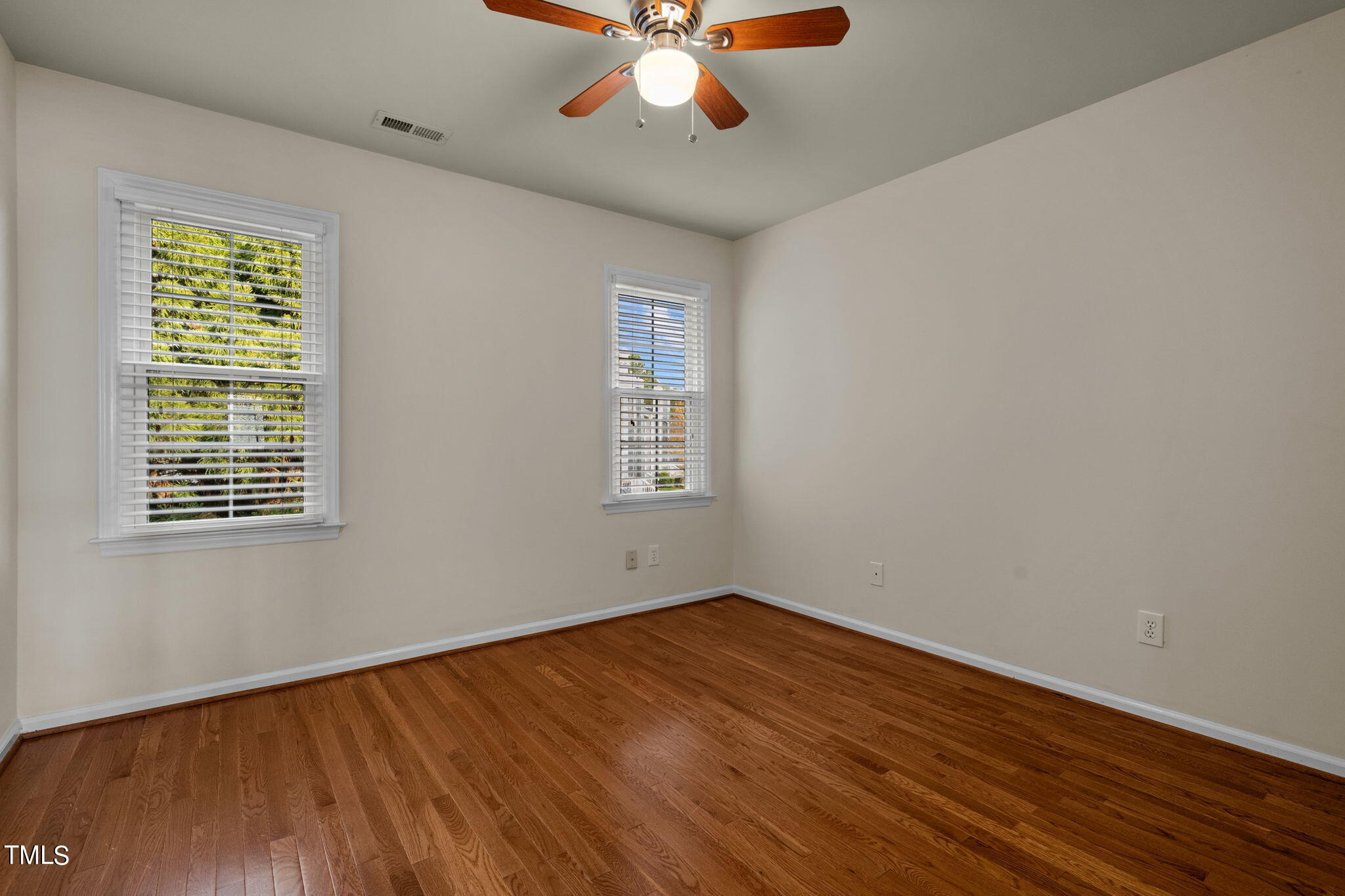 8241 Hempshire Place, Unit 102 Raleigh, NC 27613 - Photo 17 of 30 a view of an empty room with wooden floor and a window