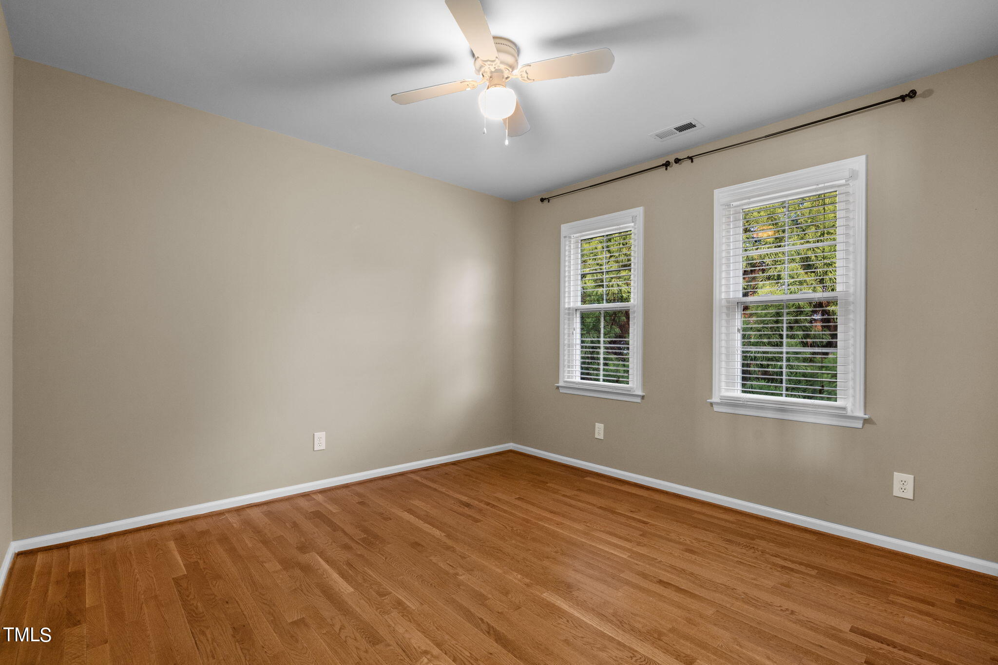 8241 Hempshire Place, Unit 102 Raleigh, NC 27613 - Photo 19 of 30 a view of an empty room with wooden floor and a window