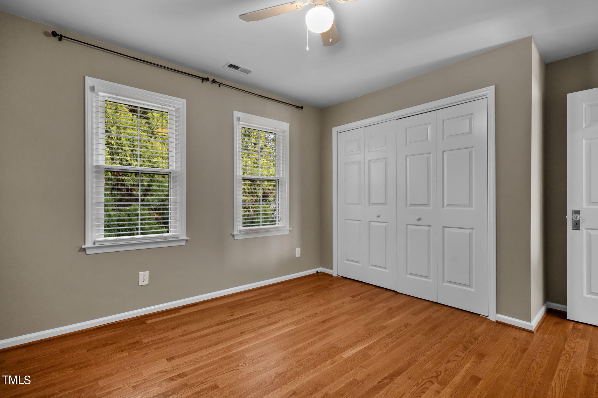 8241 Hempshire Place, Unit 102 Raleigh, NC 27613 - Photo 20 of 30 a view of an empty room with wooden floor and a window
