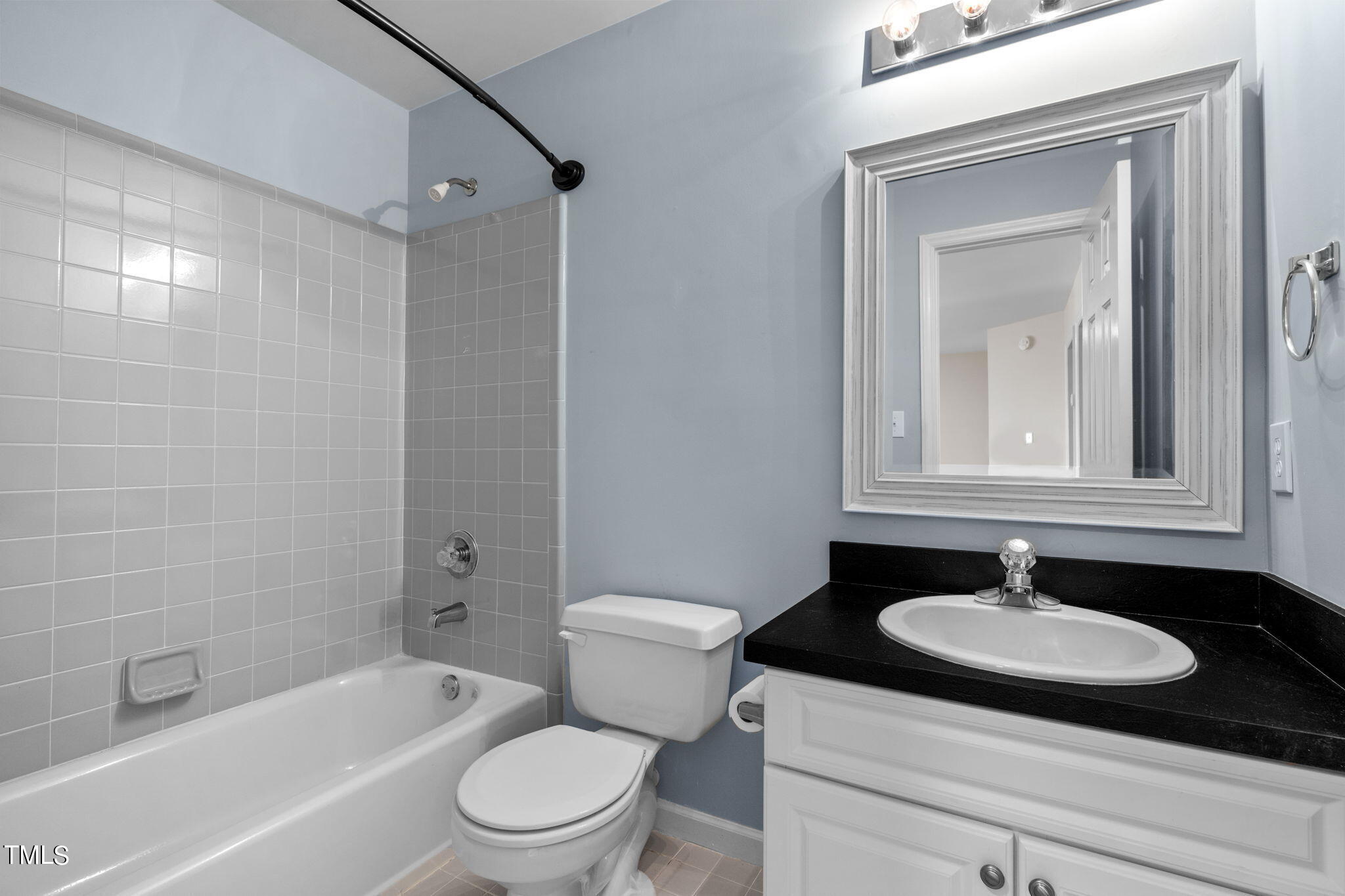 8241 Hempshire Place, Unit 102 Raleigh, NC 27613 - Photo 21 of 30 a bathroom with a sink toilet a mirror and shower