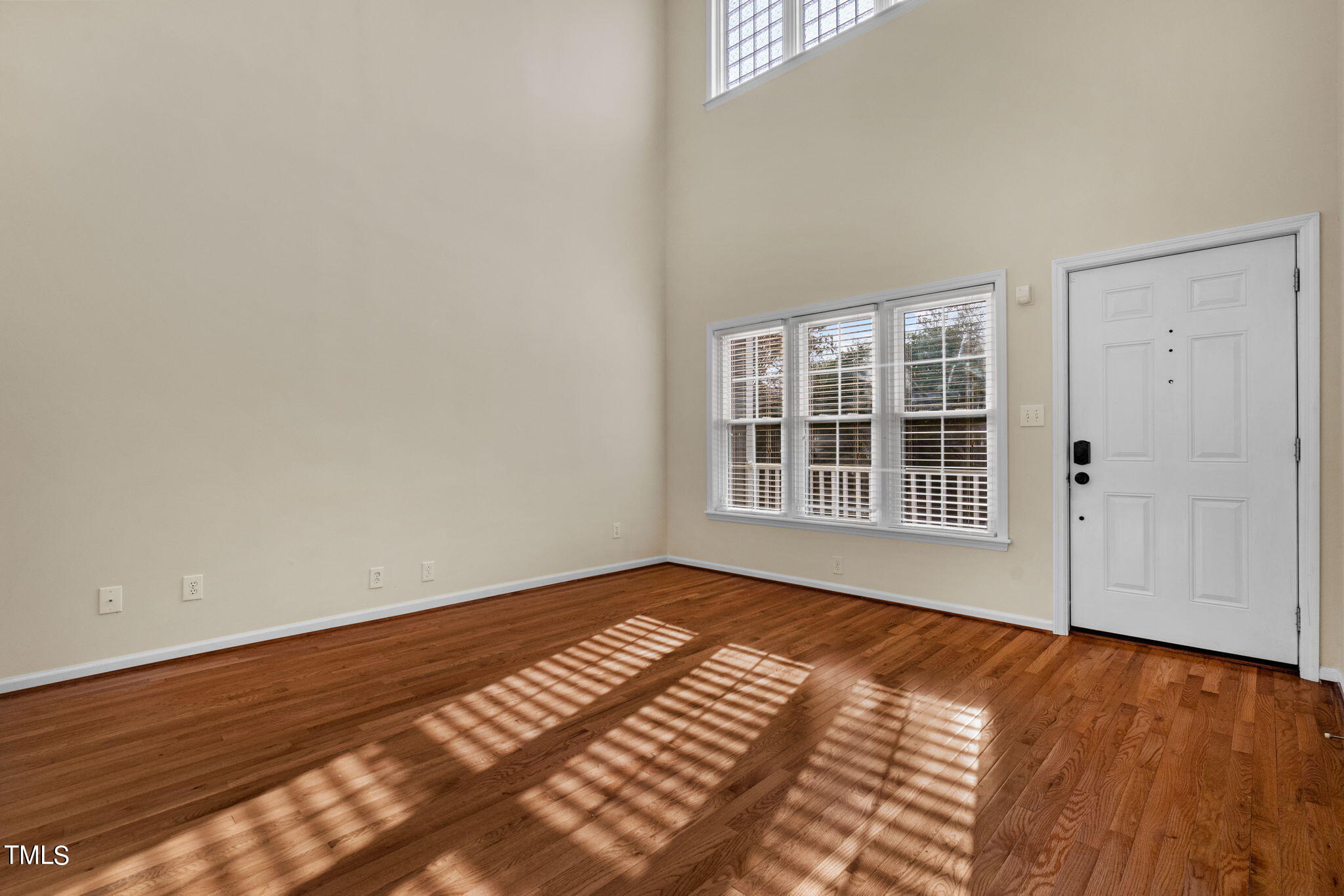 8241 Hempshire Place, Unit 102 Raleigh, NC 27613 - Photo 5 of 30 a view of an empty room with wooden floor and windows