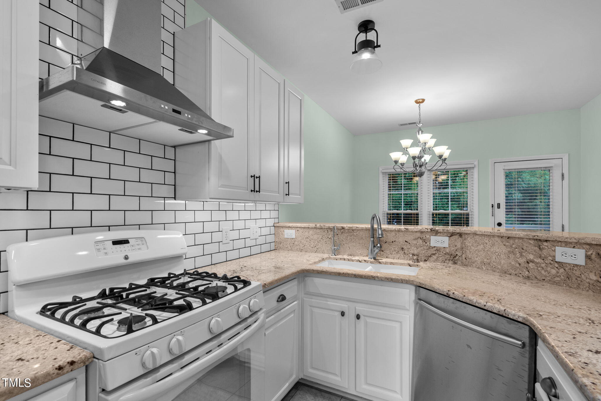 8241 Hempshire Place, Unit 102 Raleigh, NC 27613 - Photo 10 of 30 a kitchen with granite countertop stainless steel appliances a sink stove and cabinets