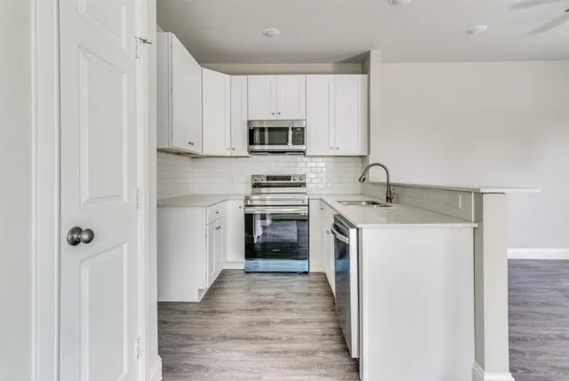 a kitchen with a sink stove and microwave