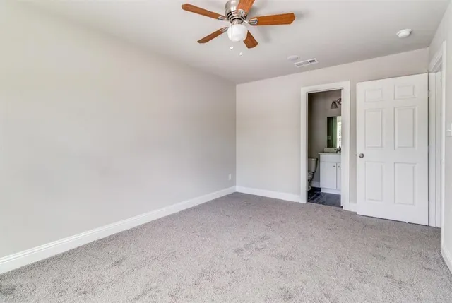 an empty room with closet and fan