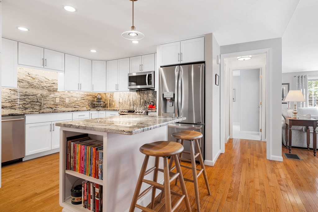 17 D Cold Spring Drive, Unit D Sutton, MA 01590 - Photo 11 of 20 a kitchen with kitchen island granite countertop wooden floor and stainless steel appliances