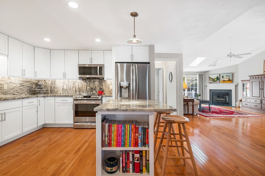17 D Cold Spring Drive, Unit D Sutton, MA 01590 - Photo 10 of 20 a kitchen with kitchen island granite countertop wooden floors and stainless steel appliances