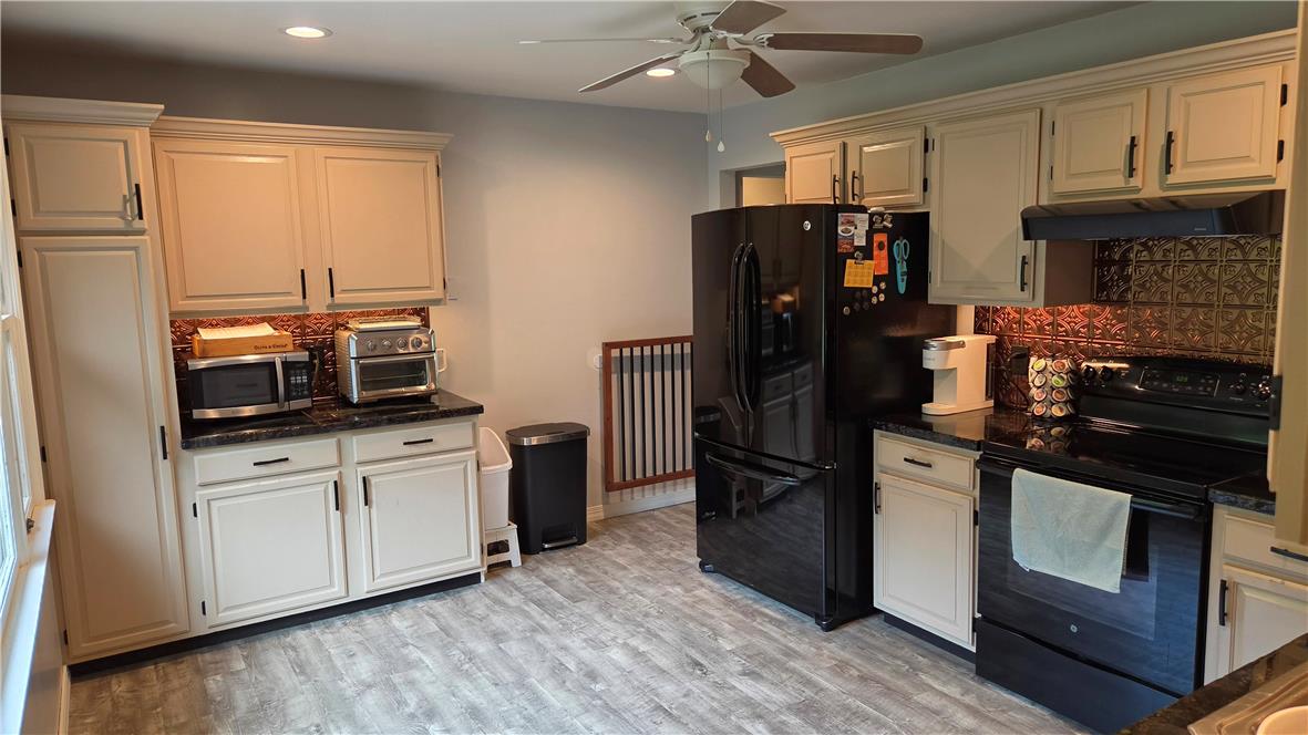 3733 Viewpoint Court Slatington, PA 18080 - Photo 5 of 25 A well-appointed kitchen features black appliances, light cabinetry, and patterned metallic backsplash tiling, offering a functional cooking space.
