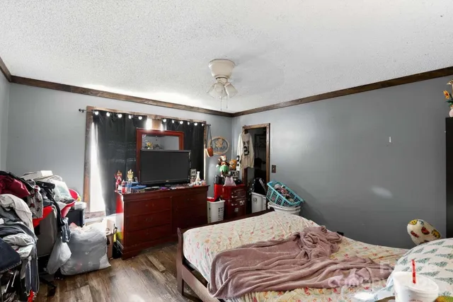 a bedroom with bed and wooden floor