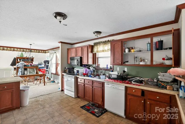 a kitchen that has a lot of cabinets a sink and appliances in it