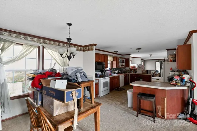 a view of a dining room with furniture and a chandelier