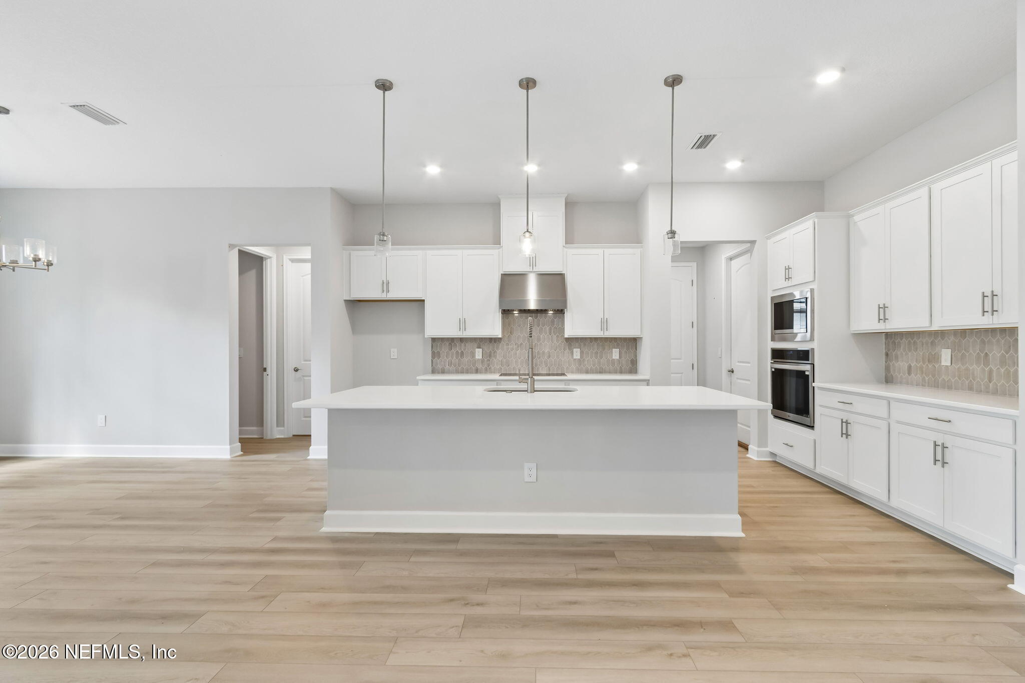 85350 Sandy Rdg Loop, Unit 39 Yulee, FL 32097 - Photo 9 of 29 a large white kitchen with kitchen island a sink stainless steel appliances and cabinets
