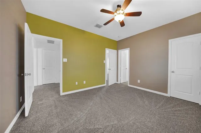 a view of an empty room with a ceiling fan