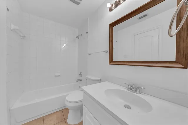 a bathroom with a toilet sink vanity tub and mirror