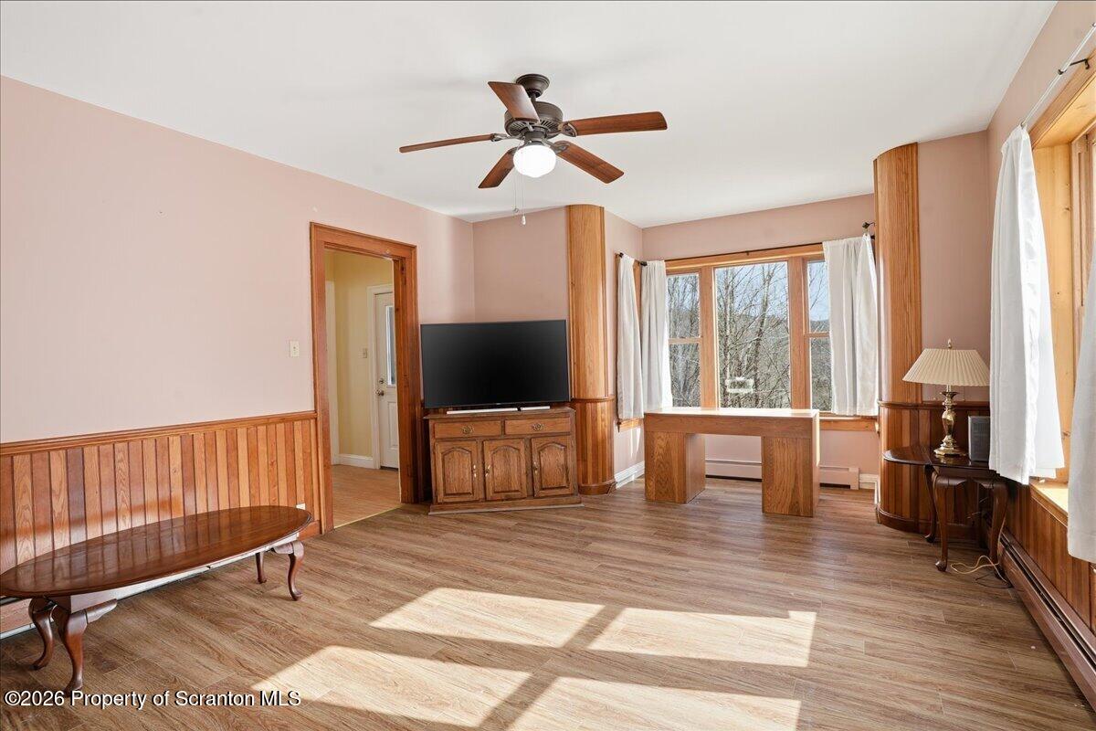795 Wescott Road New Milford, PA 18834 - Photo 22 of 81 a living room with furniture a flat screen tv and a floor to ceiling window