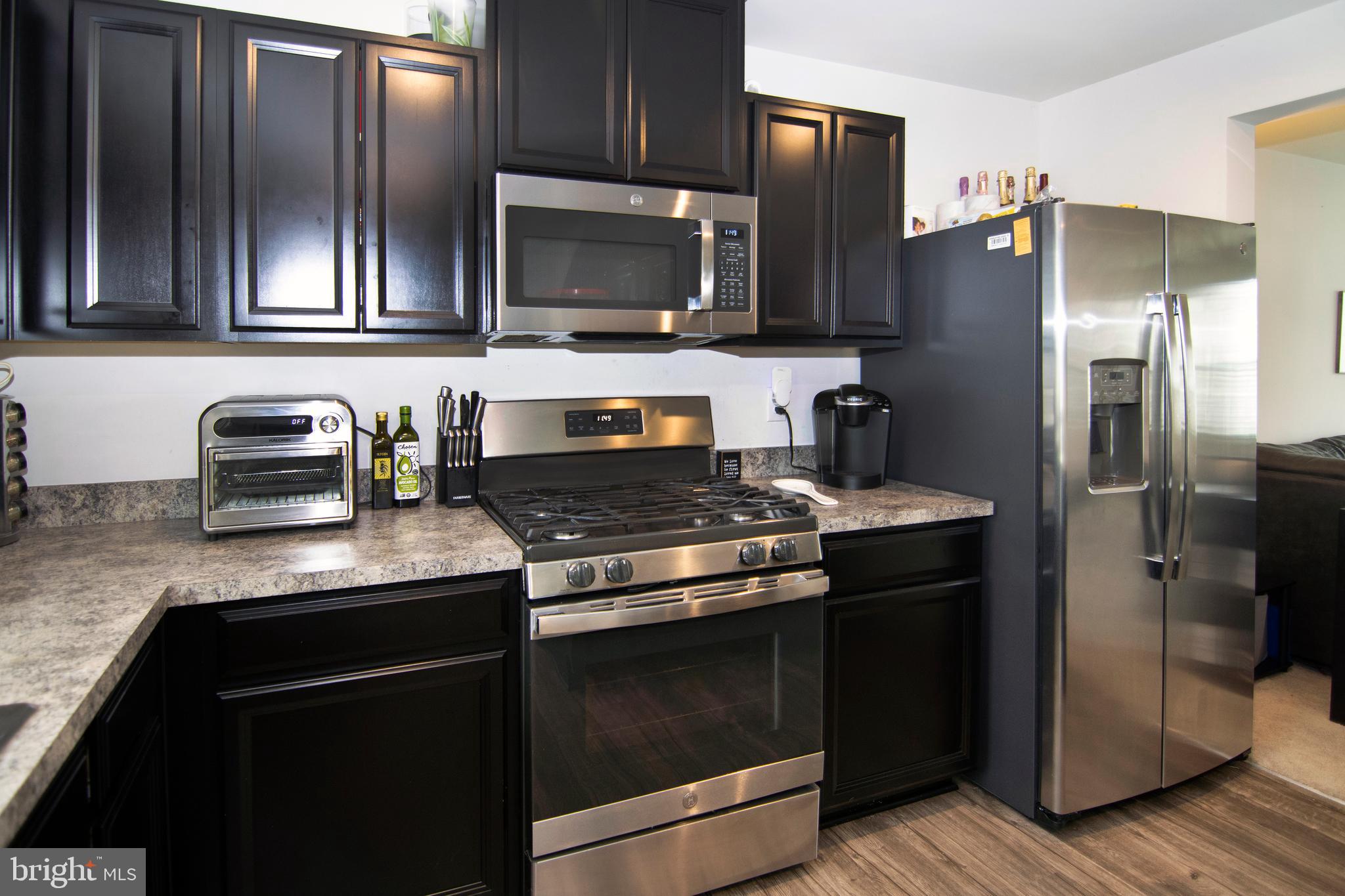 32 Burr Street Williamstown, NJ 08094 - Photo 13 of 34 a kitchen with stainless steel appliances granite countertop a stove microwave refrigerator and sink