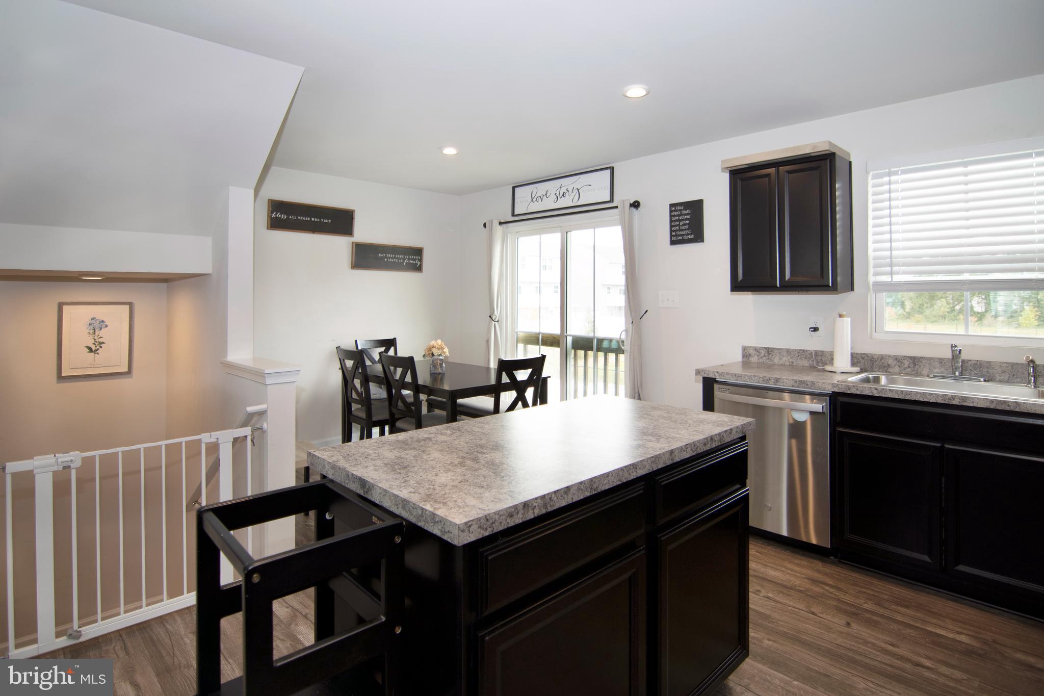 32 Burr Street Williamstown, NJ 08094 - Photo 14 of 34 a kitchen with granite countertop a sink dishwasher a stove a refrigerator a dining table and chairs with wooden floor