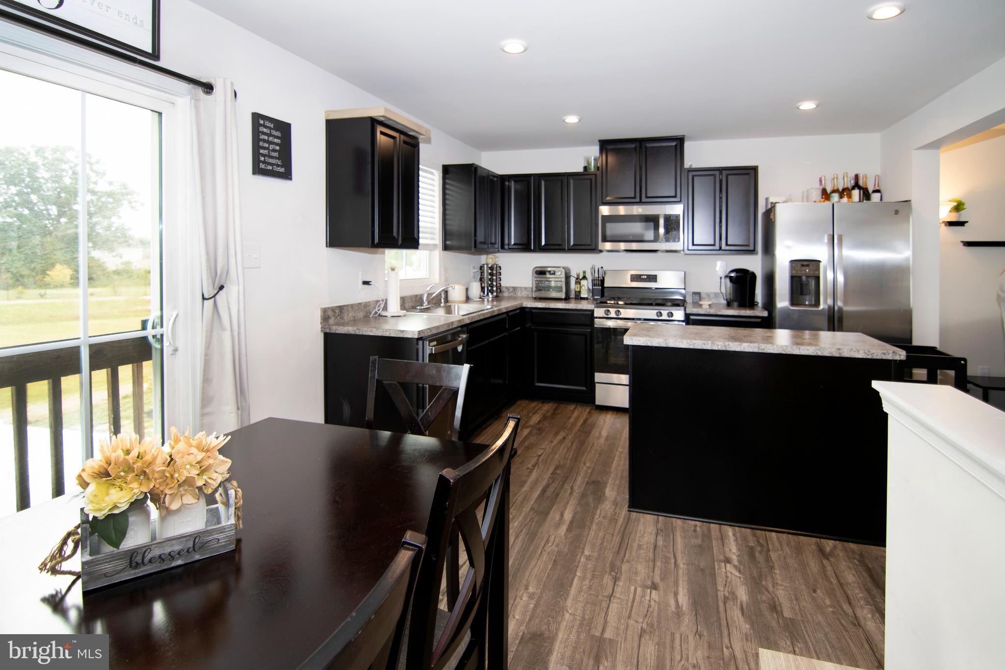 32 Burr Street Williamstown, NJ 08094 - Photo 9 of 34 a kitchen with stainless steel appliances granite countertop a sink a stove a refrigerator a dining table and chairs