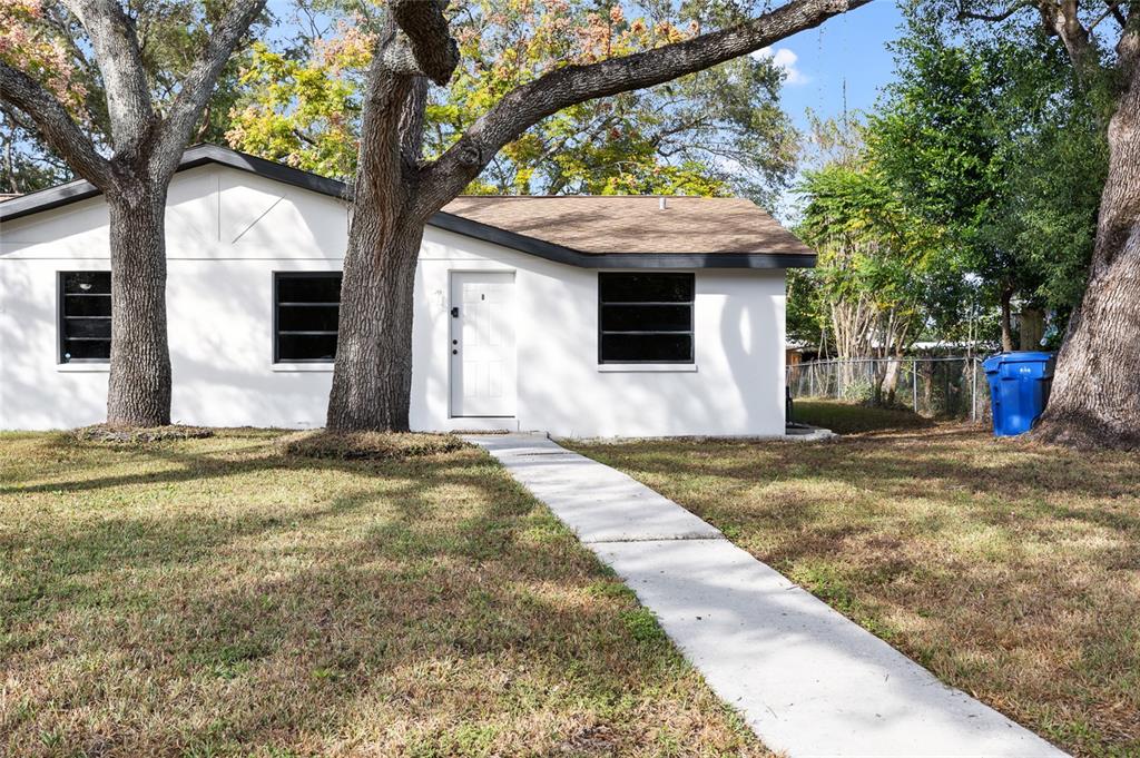 1220 East 142nd Avenue Tampa, FL 33613 - Photo 16 of 36 a front view of a house with a yard