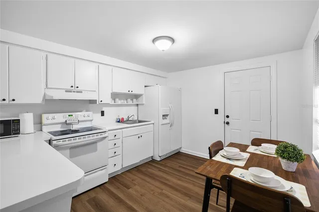 a kitchen with white cabinets and stove