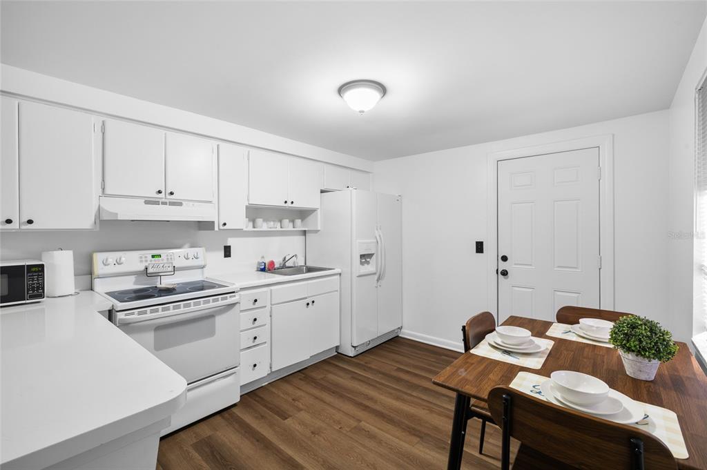 1220 East 142nd Avenue Tampa, FL 33613 - Photo 23 of 36 a kitchen with white cabinets and stove