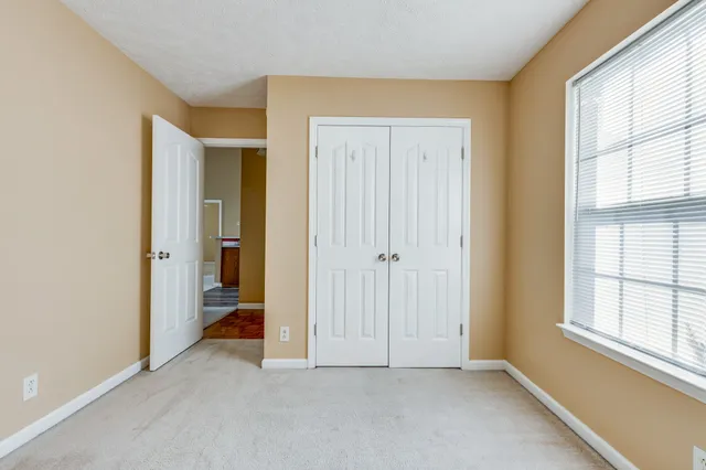 an empty room with windows and closet