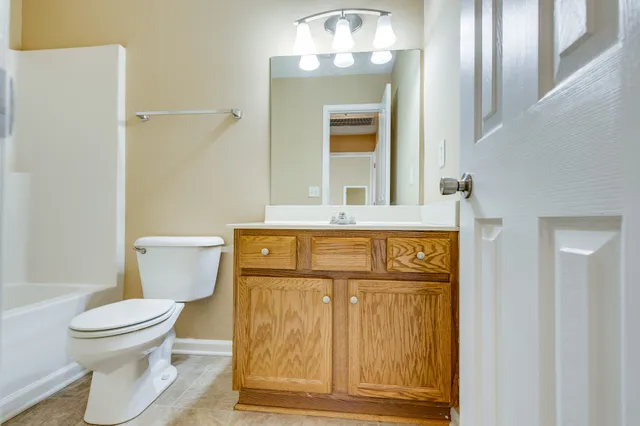 a bathroom with a granite countertop toilet sink and mirror