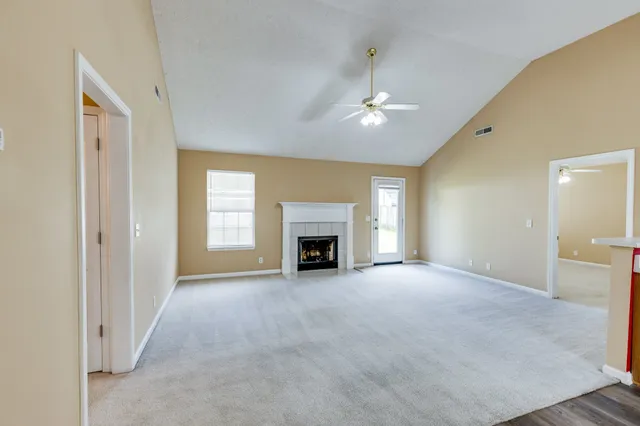 a view of an empty room with a fireplace and a window