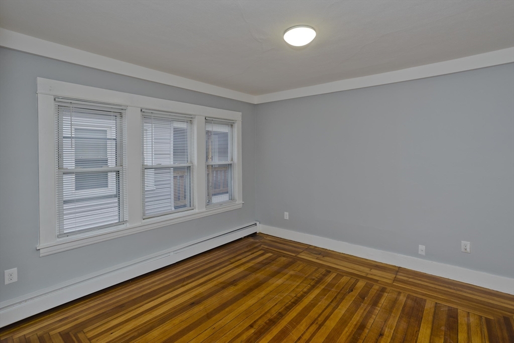 298 Oakland Street Springfield, MA 01108 - Photo 5 of 38 an empty room with wooden floor and windows