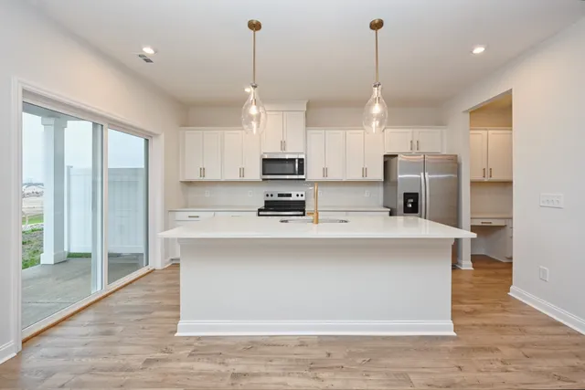 a view of kitchen with stainless steel appliances granite countertop cabinets and a wooden floor
