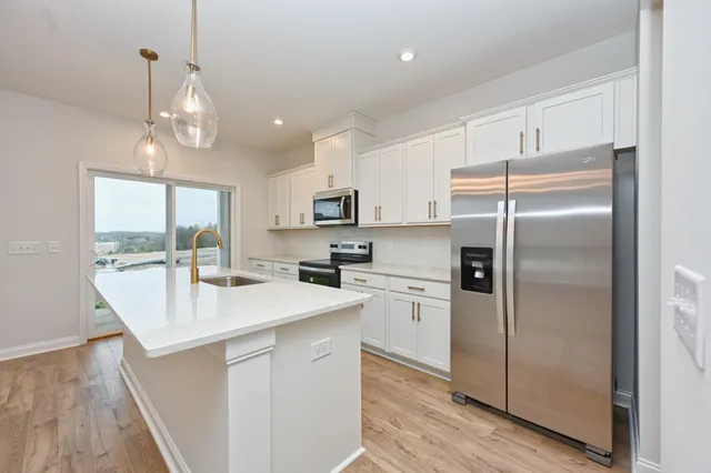 a kitchen with kitchen island white cabinets and stainless steel appliances