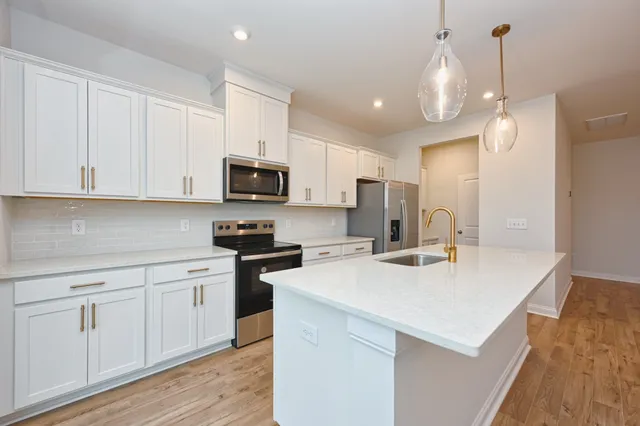 a kitchen with a sink a microwave and cabinets