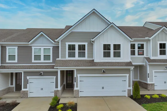 a front view of a house with a garage and outdoor seating