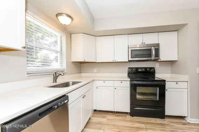 a kitchen with a sink stove and microwave
