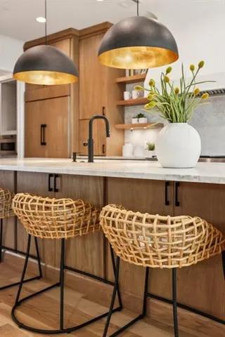 a kitchen with stainless steel appliances granite countertop a stove a sink and white cabinets with wooden floor