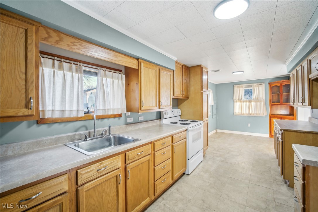 754 Fettro Road Akron, OH 44312 - Photo 6 of 31 Kitchen with light countertops, electric stove, baseboards, and a sink