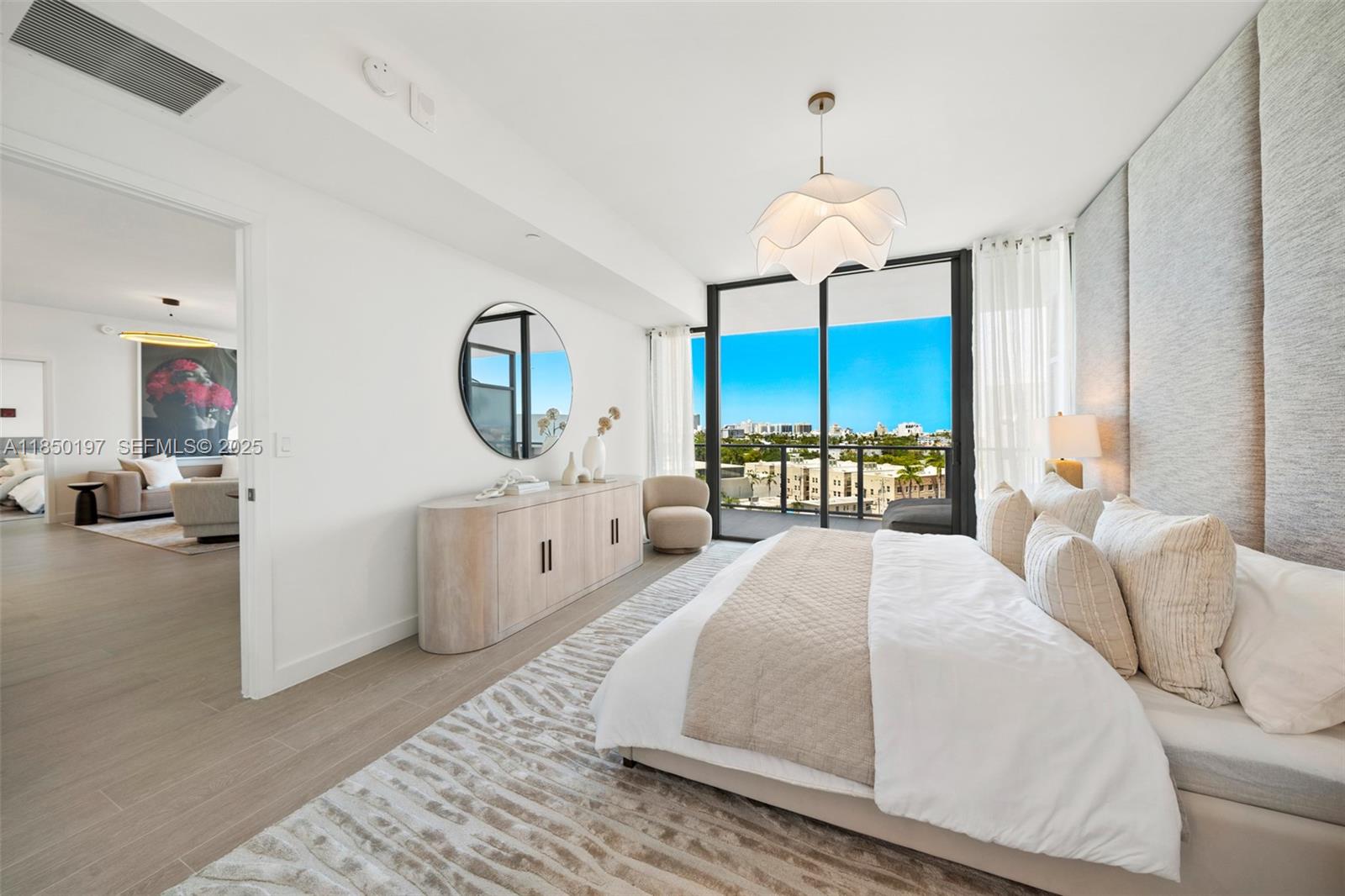 500 Alton Road, Unit 807 Miami Beach, FL 33139 - Photo 13 of 20 a bedroom with a large bed and a chandelier