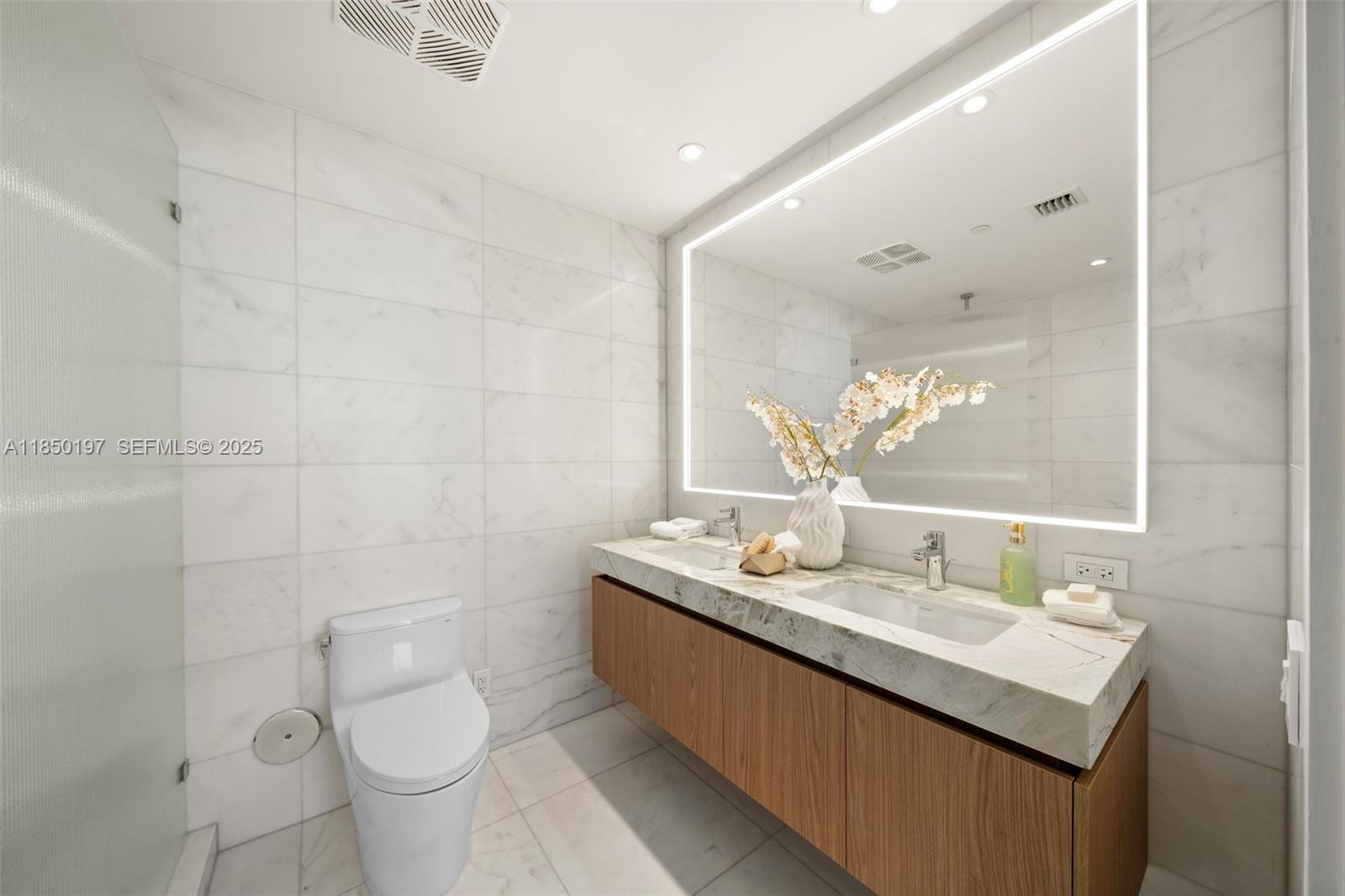 500 Alton Road, Unit 807 Miami Beach, FL 33139 - Photo 15 of 20 a bathroom with a granite countertop sink a toilet and a mirror