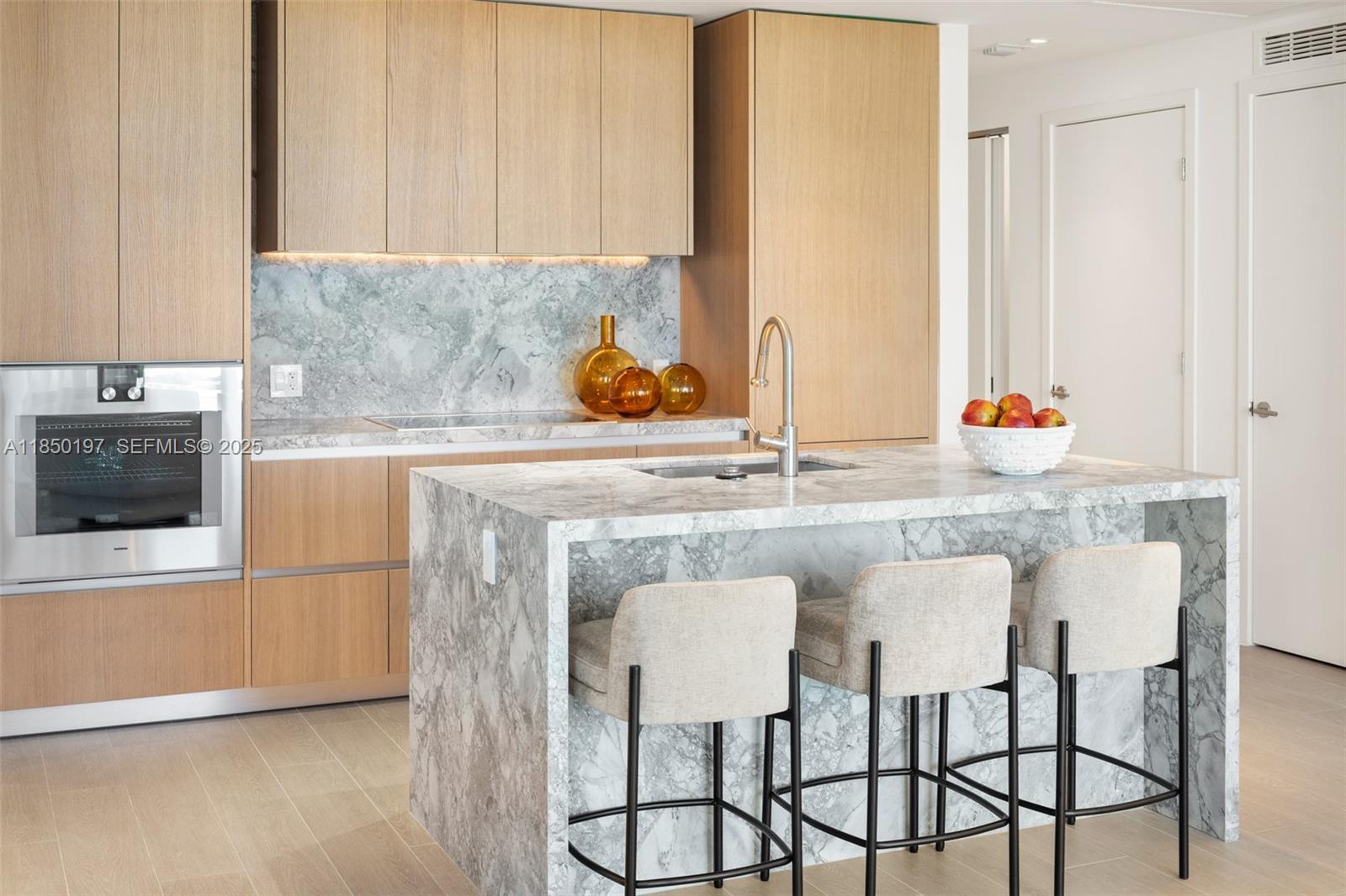 500 Alton Road, Unit 807 Miami Beach, FL 33139 - Photo 9 of 20 a kitchen with stainless steel appliances granite countertop a table and chairs in it