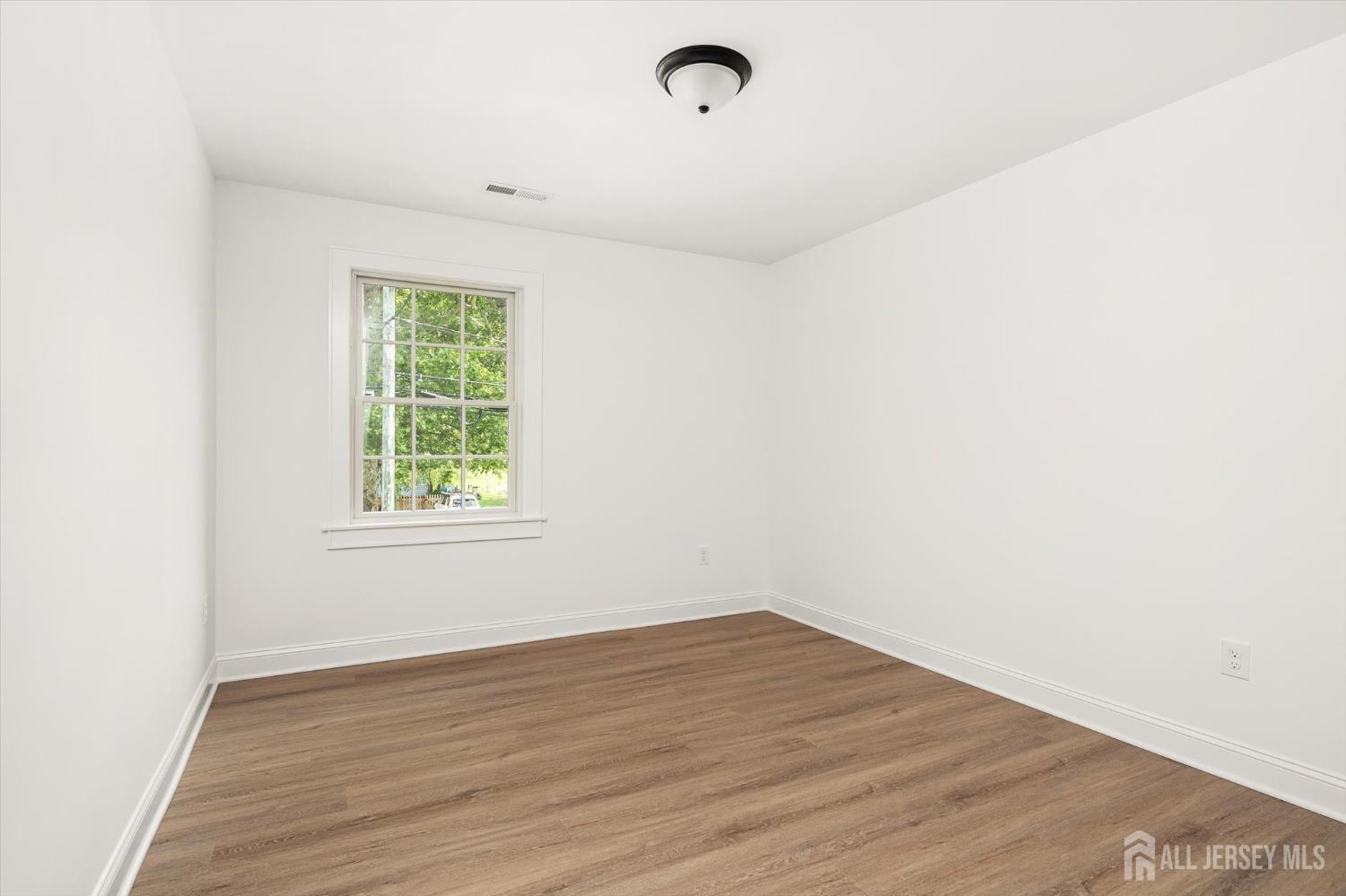 438 Ellisdale Road Chesterfield, NJ 08515 - Photo 16 of 28 an empty room with wooden floor and windows