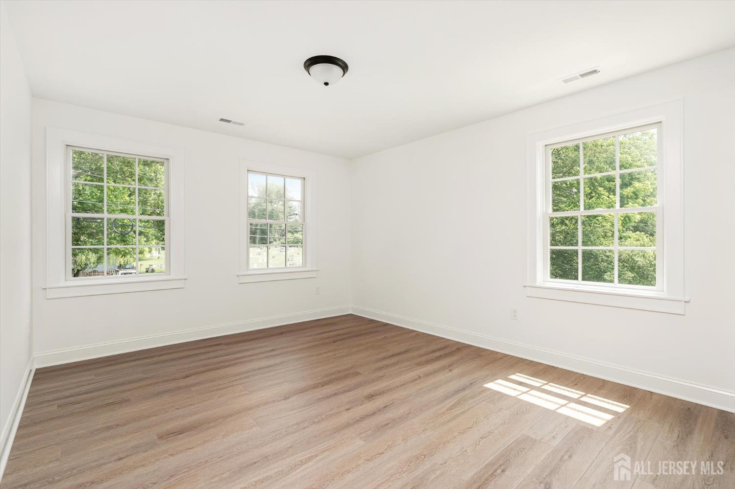 438 Ellisdale Road Chesterfield, NJ 08515 - Photo 17 of 28 an empty room with wooden floor and windows
