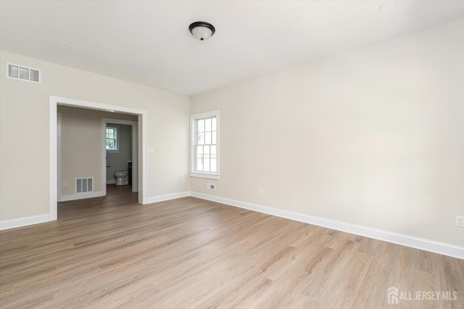 438 Ellisdale Road Chesterfield, NJ 08515 - Photo 7 of 28 an empty room with wooden floor and windows